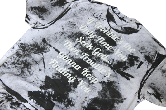 Black and white tie-dye hoodie with text on a wooden surface