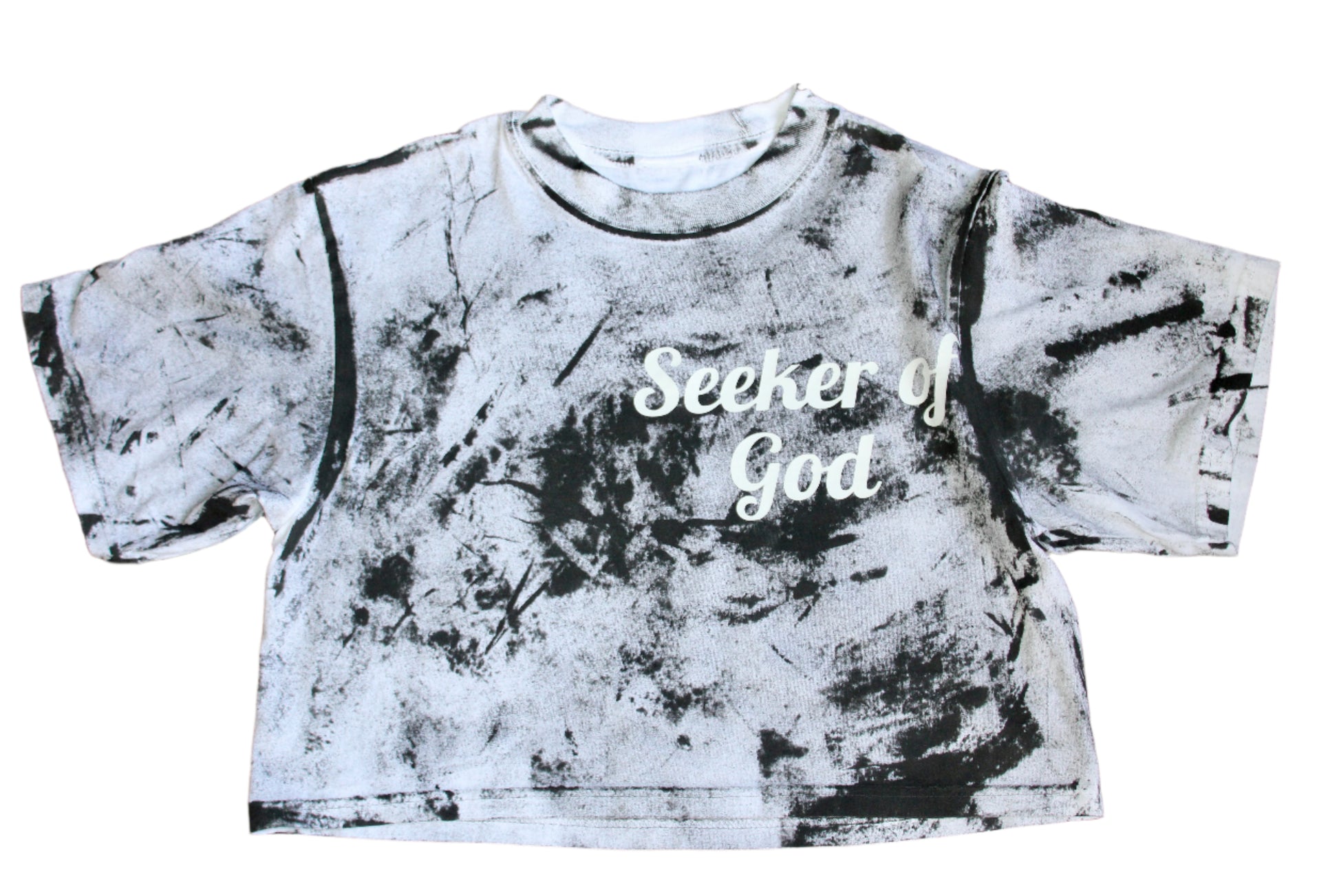 Black and white tie-dye crop top with 'Seeker of God' text on a wooden floor.
