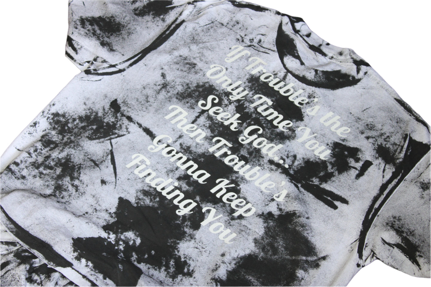 Black and white tie-dye hoodie with text on a wooden surface